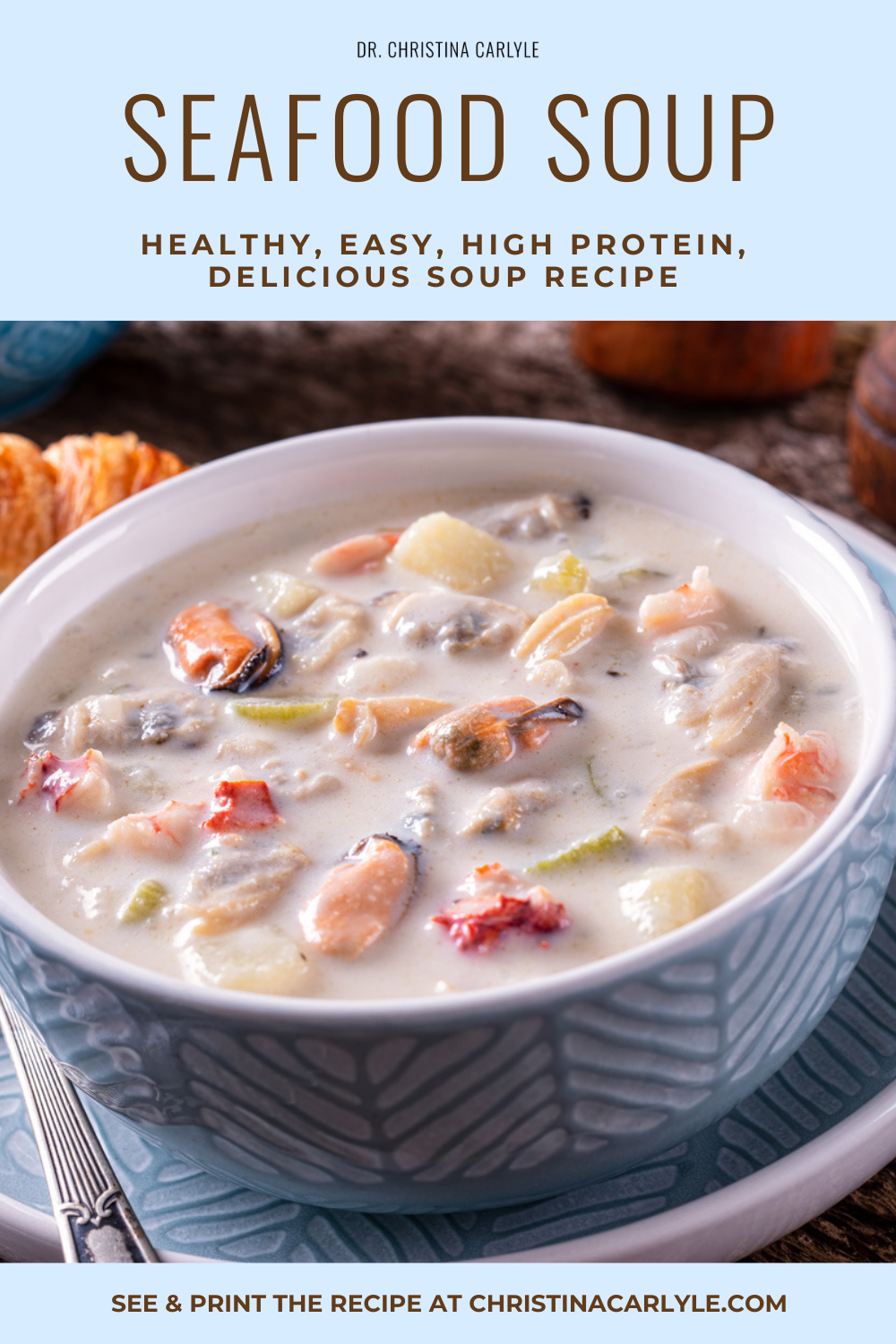Seafood soup in a blue bowl with a creamy broth, shrimp, clams, and potato pieces, with text overlay reading “Seafood Soup, healthy easy high protein."