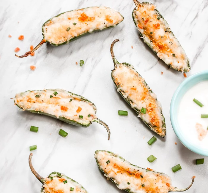 Healthy Baked Jalapeño Poppers on a countertop with a dipping sauce