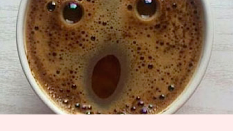Cup of black coffee with face in the foam