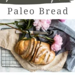 a loaf of bread on a cutting board on a counter and text that says Paleo Bread