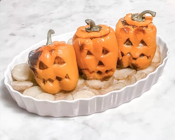 3 cooked stuffed peppers that look like jack o lanterns