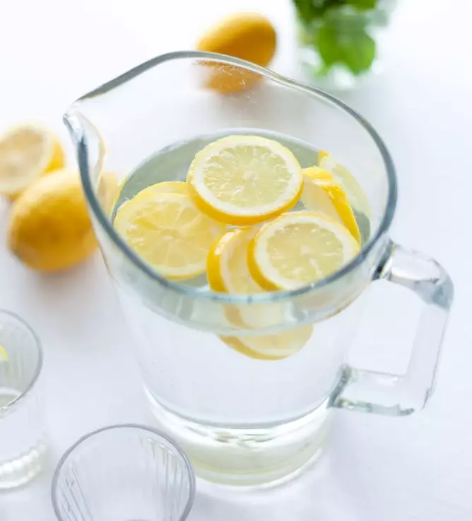 Pitcher of Lemon Water and lemon water ingredients on an countertop