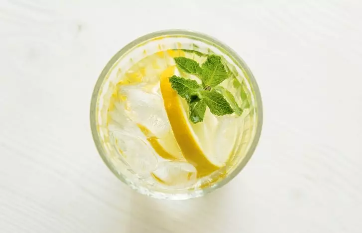 Flat lay of Iced Lemon water with lemon and mint