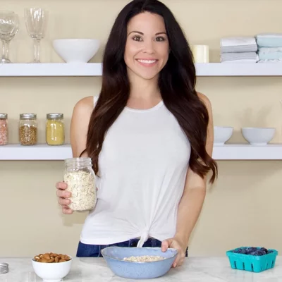 Nutritionist Christina Carlyle in a kitchen holding oats