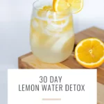 a glass of lemon water and lemons on a cutting board and text that says 30 Day Lemon Water Detox