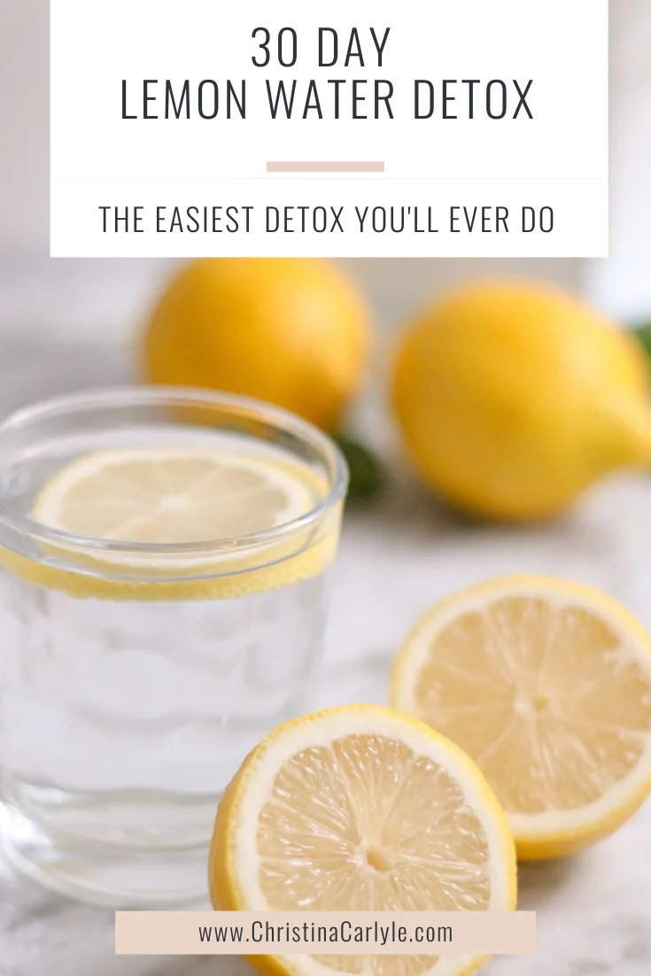a glass of lemon water and lemons on a countertop and text that says 30 Day Lemon Water Detox