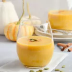 Pumpkin Smoothie on a table with mini pumpkins and gourds