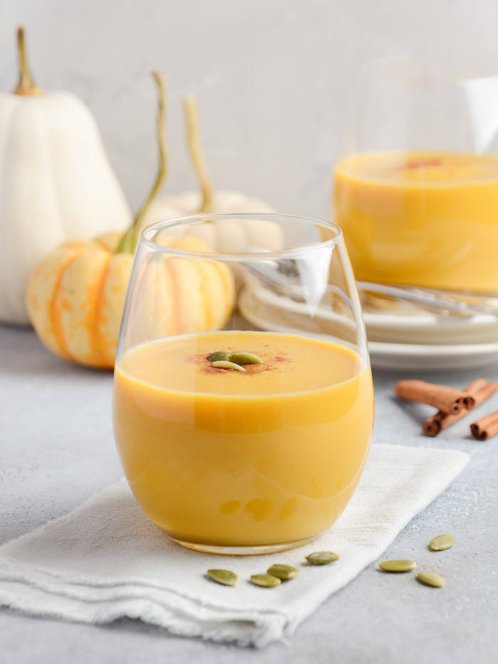 2 pumpkin smoothies with mini pumpkins and gourds