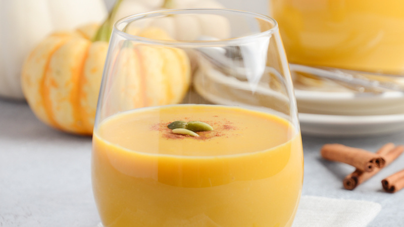 Pumpkin Smoothie with mini pumpkin and gourds on a table