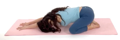 Christina Carlyle doing a child's pose lower back stretch