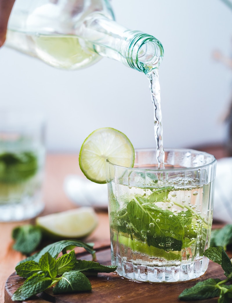 pouring a glass of water with lime and mint