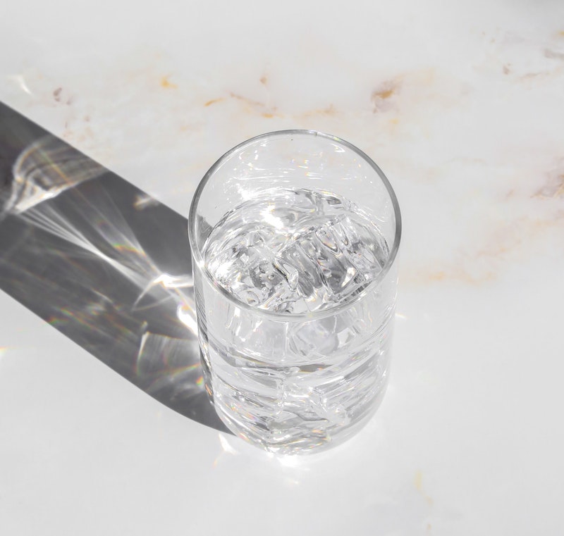 a glass of ice water on a countertop