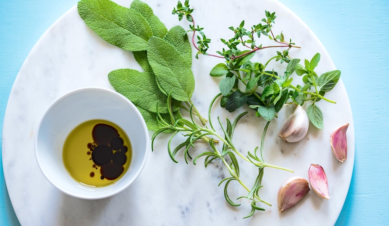 A flay lay with infused olive oil and herbs