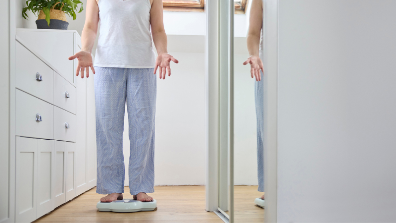 a frustrated woman standing on a scale