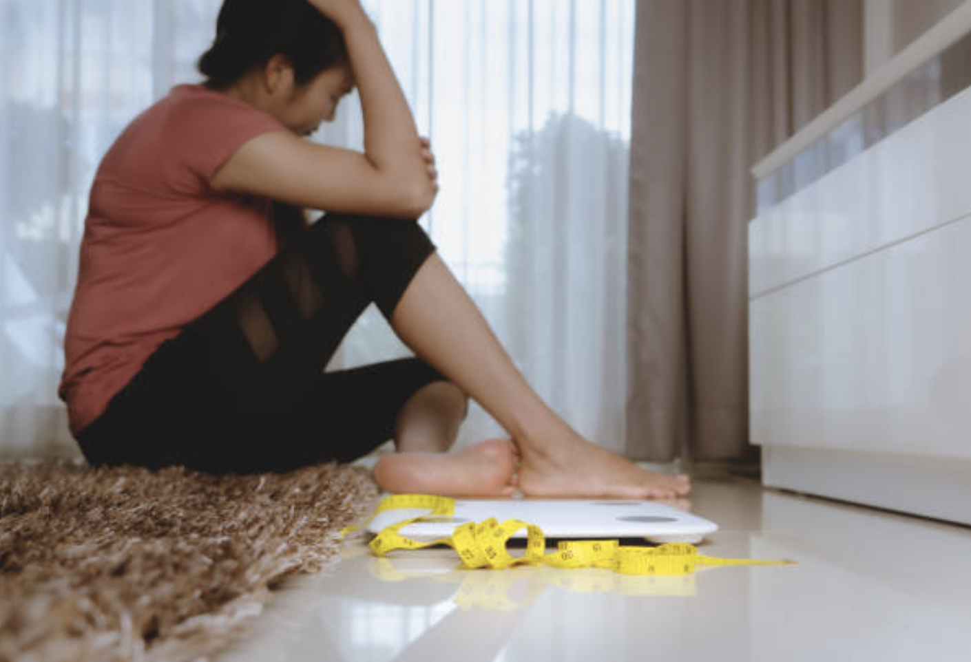 A frustrated woman next to a scale