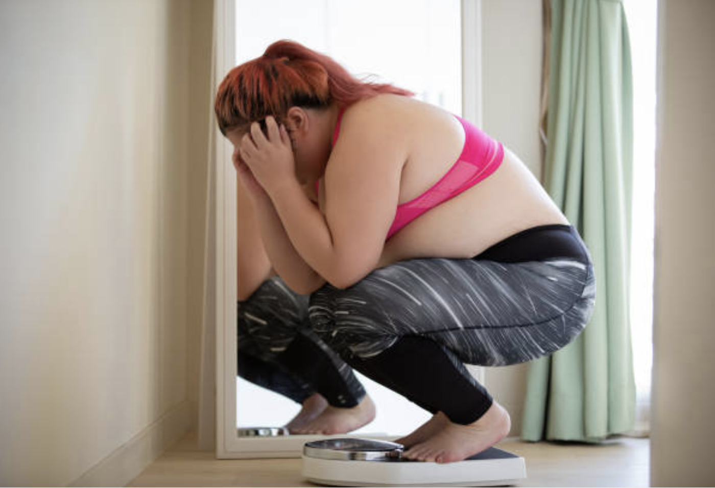 an obese woman upset and frustrated on a scale