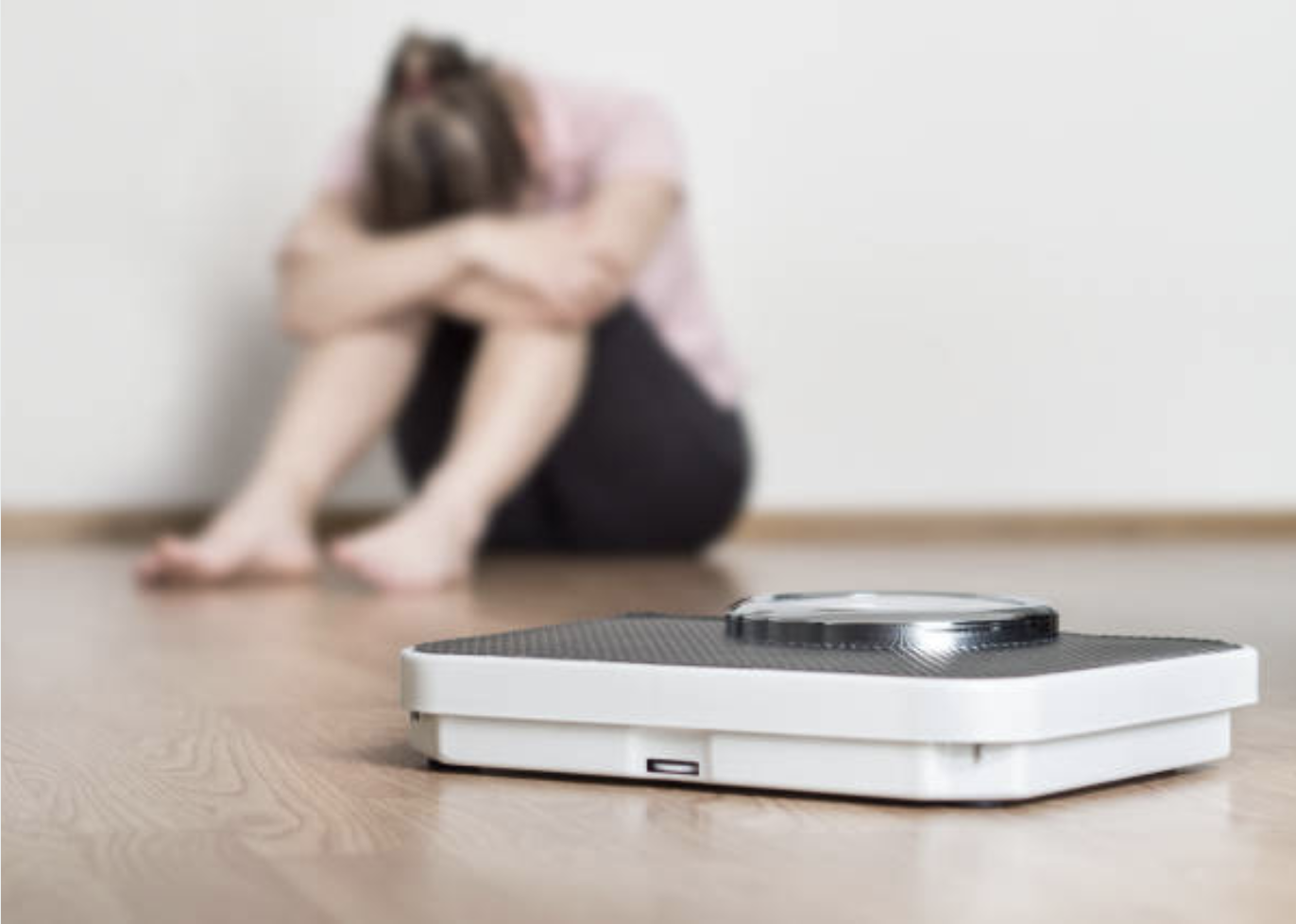 a woman upset next to a scale