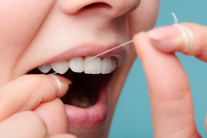 a woman flossing her teeth