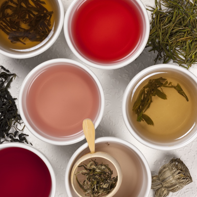 a flat-lay of different healthy teas and tea leaves