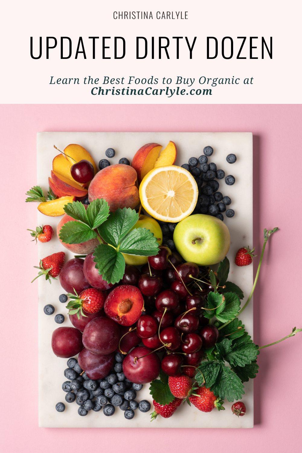 a flatlay of grapes, cherries, strawberries, apples, blueberries, and other dirty dozen fruits and text that says Updated Dirty Dozen - What to Buy Organic