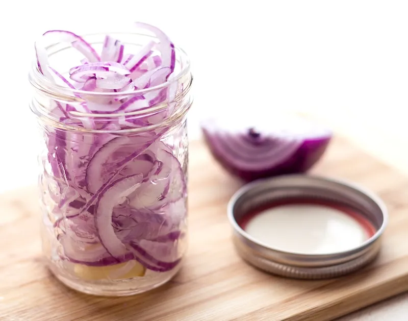 Sliced red onions in a glass jar
