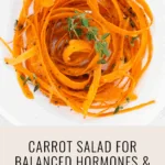 a bowl of carrot salad, carrot ribbons dressing in oil and herbs and text that says CARROT SALAD FOR BALANCED HORMONES & GLOWING SKIN