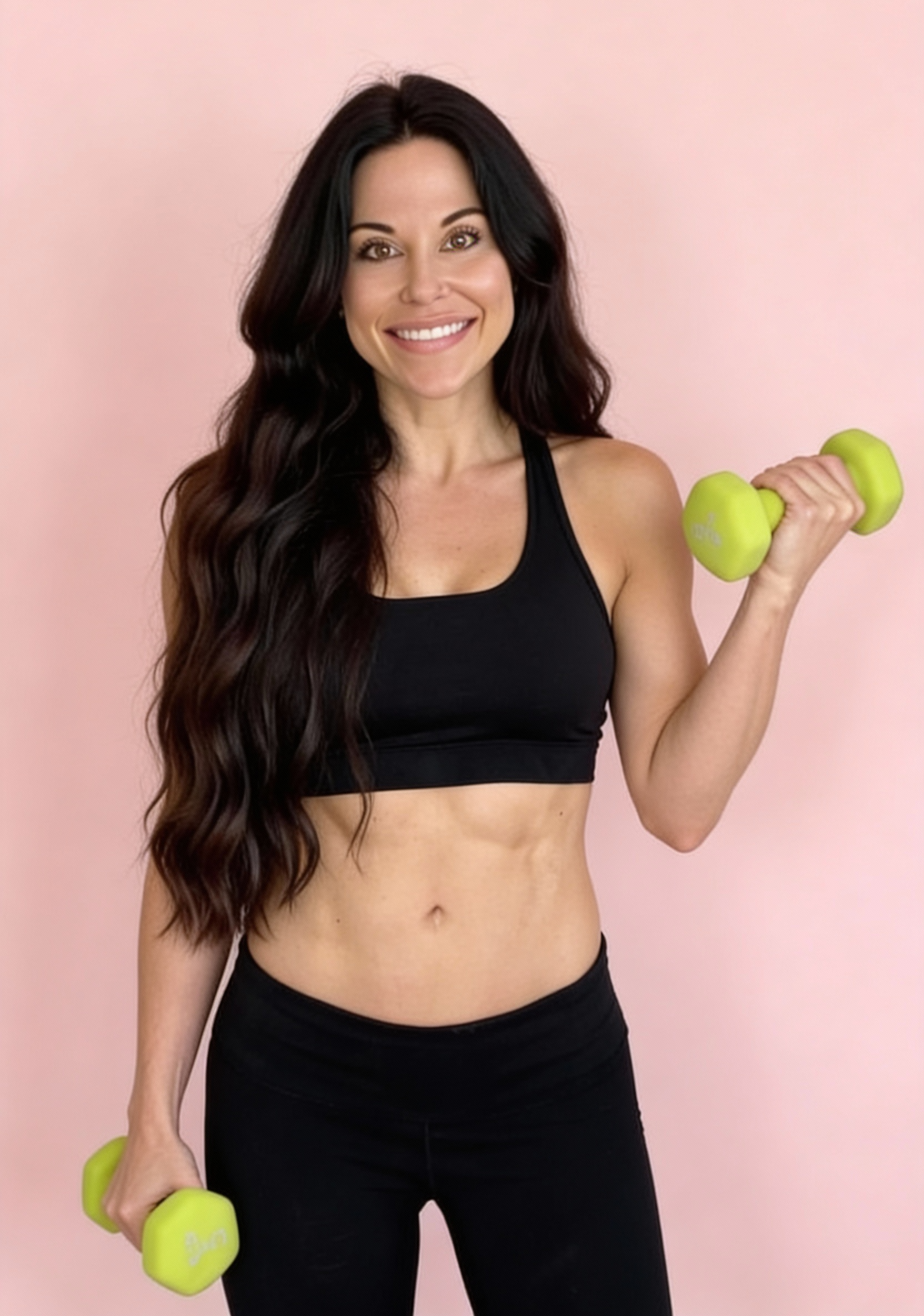 Personal trainer Dr. Christina Carlyle smiling while holding green dumbbells, wearing a black sports bra and leggings against a soft pink background, showcasing a fit and confident physique