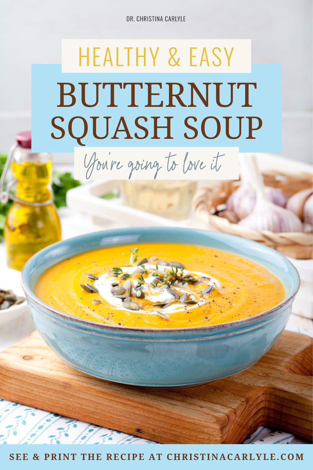 Butternut squash soup in a blue bowl topped with pumpkin seeds, herbs, and a cream swirl, with text overlay reading “Healthy and Easy Butternut Squash Soup.”
