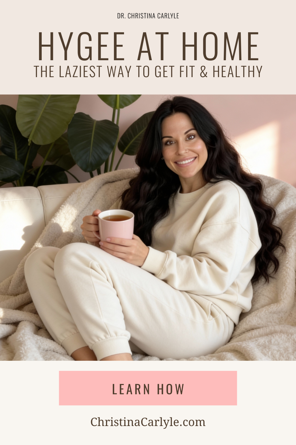 Hygge at Home Dr. Christina Carlyle relaxing at home in cozy neutral loungewear while holding a warm mug on a sofa, demonstrating hygge inspired wellness and gentle at home fitness for healing metabolism, nervous system support, and sustainable health.